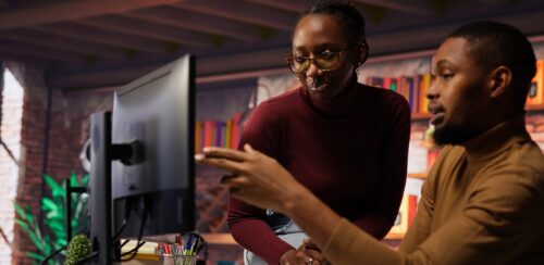 IT worker and colleague programming in AI startup office to build applications